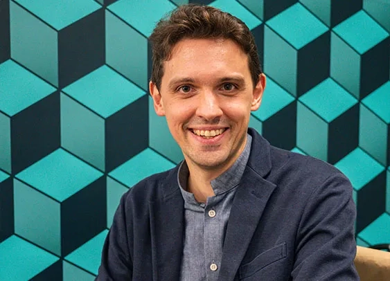 Image d'une Alexa avec anneau lumineux bleu allumé, posée sur une table dans un salon.